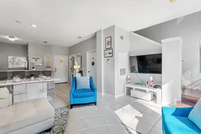 a living room with a blue chair and a table at Zen Escape At Terra Verde By Shine Villas in Kissimmee