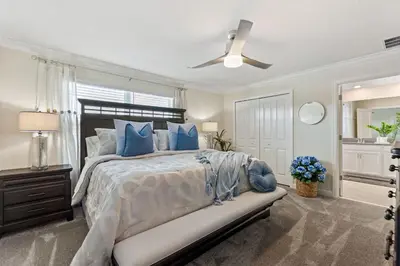 a bedroom with a large bed with blue pillows at Plush Pelican, At Storey Lake By Shine Villas #839 in Kissimmee