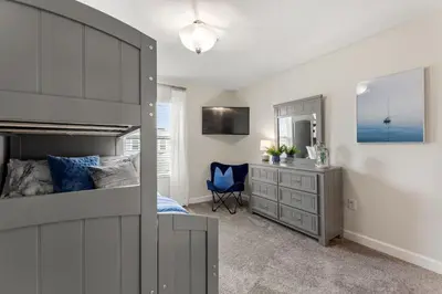 a bedroom with a bed and a desk and a mirror at Plush Pelican, At Storey Lake By Shine Villas #839 in Kissimmee