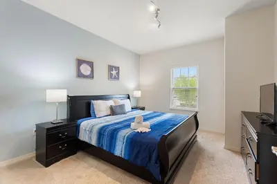 a bedroom with a large bed with a blue comforter at Lucky Find Lucaya Resort By Shine Villas 713 in Kissimmee