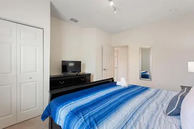 a bedroom with a large bed with a blue blanket at Lucky Find Lucaya Resort By Shine Villas 713 in Kissimmee