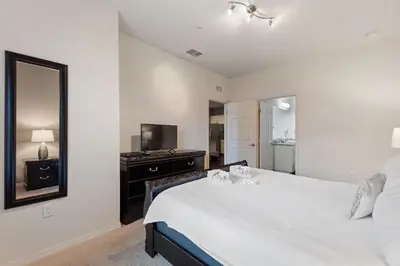 a bedroom with a large bed and a mirror at Lucky Find Lucaya Resort By Shine Villas 713 in Kissimmee