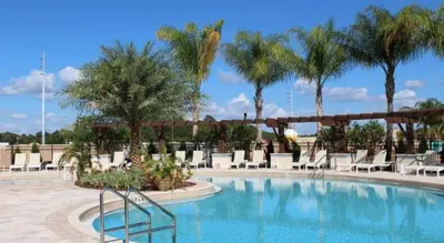 a pool at a resort with chairs and palm trees at Lucky Find Lucaya Resort By Shine Villas 713 in Kissimmee