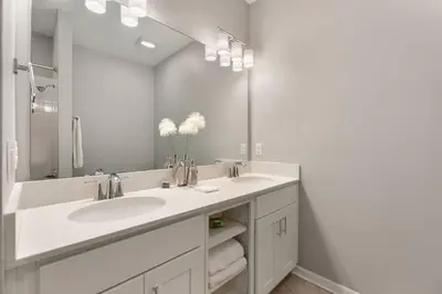 a bathroom with two sinks and a large mirror at Fireworks Night -Storey Lake By Shine Villas #709 in Kissimmee