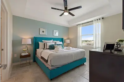 a bedroom with a blue bed with a ceiling fan at Resort Life At Storey Lake By Shine Villas #702 in Kissimmee
