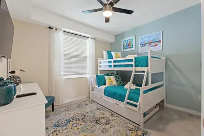 a bedroom with two bunk beds and a desk at Resort Life At Storey Lake By Shine Villas #702 in Kissimmee