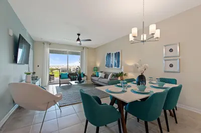 a dining room and living room with a table and chairs at Resort Life At Storey Lake By Shine Villas #702 in Kissimmee
