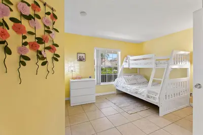 a room with two bunk beds and flowers on the wall at Gilded Parasol By Shine Villas Remington Golf 420 in Kissimmee