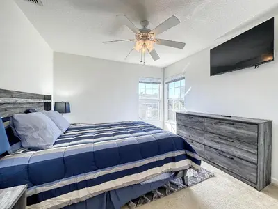a bedroom with a bed and a ceiling fan at Luxury 6BD 3.5BA Pool Home in Windsor Palms Resort in Kissimmee