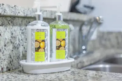 two bottles of soap sitting on a counter next to a sink at Enjoy a Cozy 3 BR/Clubhouse/Near Disney and more in Kissimmee