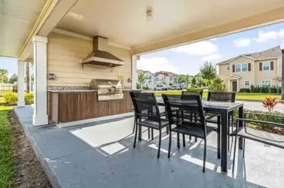 a patio with a black table and chairs at Enjoy a Cozy 3 BR/Clubhouse/Near Disney and more in Kissimmee