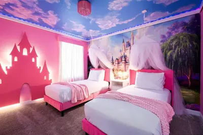 a pink bedroom with two beds and a castle mural at Luxury 9BR Gem- Heated Pool, Theater & Theme Rooms in Kissimmee