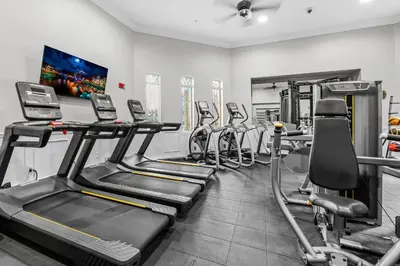 a fitness room with several treadmills and machines at Prime Location 3 Suites Townhome Near Universal in Orlando