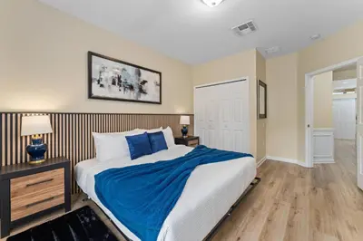 a bedroom with a large bed with blue pillows at Luxury 3-Suite Townhome Resort Near Universal in Orlando