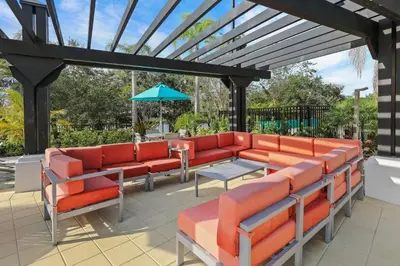 a patio with orange chairs and a blue umbrella at Luxury 3-Suite Townhome Resort Near Universal in Orlando