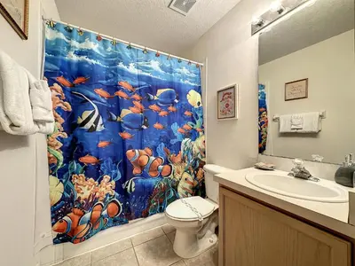 a bathroom with a shower curtain with a fish at Lovely 3 bed Condo Near Disney Quiet Community in Kissimmee