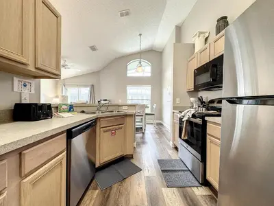 a kitchen with wooden cabinets and stainless steel appliances at Four Bed Three Bath in a gated community with pool in Kissimmee