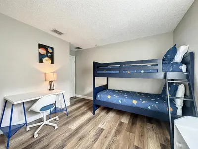 a bedroom with two bunk beds and a desk at Four Bed Three Bath in a gated community with pool in Kissimmee