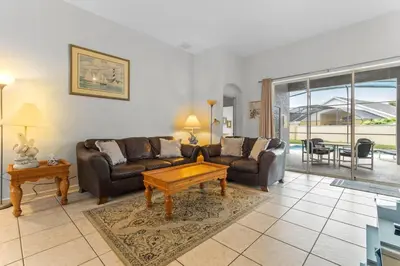a living room with a couch and a table at Three Bed Private Pool Villa just steps away from in Kissimmee