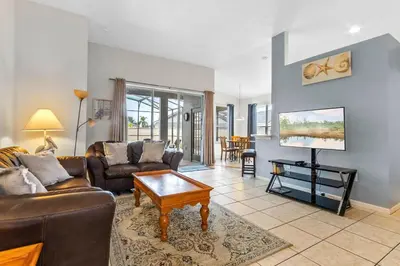 a living room with a couch and a table at Three Bed Private Pool Villa just steps away from in Kissimmee