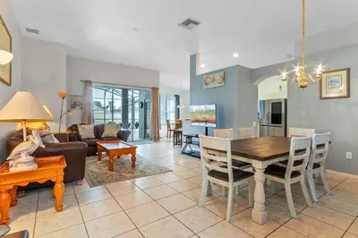a living room with a table and a dining room at Three Bed Private Pool Villa just steps away from in Kissimmee