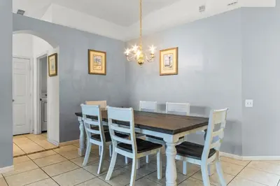 a dining room with a wooden table and chairs at Three Bed Private Pool Villa just steps away from in Kissimmee