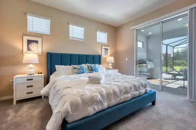 a bedroom with a large bed with a blue headboard at DLuxx Summer Vacation Home at Solterra Resort 7391 in Orlando