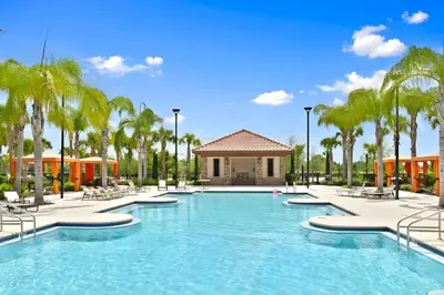 a pool at a resort with chairs and palm trees at DLuxx Summer Vacation Home at Solterra Resort 7391 in Orlando
