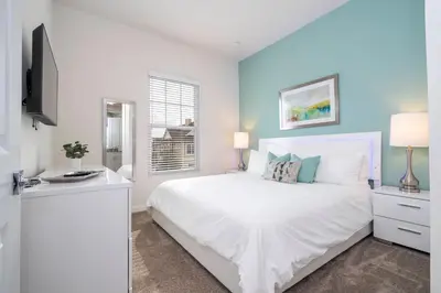 a bedroom with a white bed and a window at 5 min to Disney NEW Upscale 5 Suites Villa in Orlando