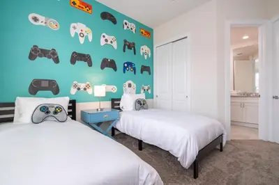 a bedroom with two beds and a blue wall at 5 min to Disney NEW Upscale 5 Suites Villa in Orlando
