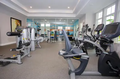 a gym with several treadmills and cardio machines at 5 min to Disney NEW Upscale 5 Suites Villa in Orlando