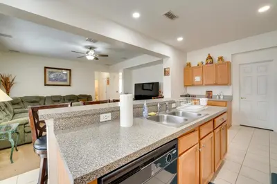 a kitchen with a sink and a living room at 22 Mi to Disney Kissimmee Home with Pool and Hot Tub in Kissimmee