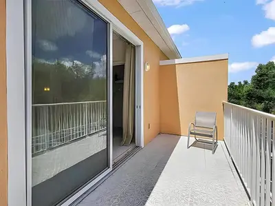 a chair sitting on the balcony of a house at MEMO Vacation House in Orlando