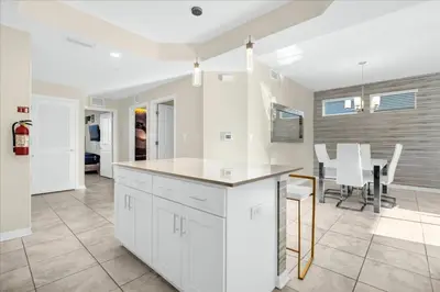 a kitchen with white cabinets and a dining room at 3 Bedrooms 2 Bathrooms Storey Lake 3111-101Pc in Kissimmee