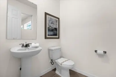 a white bathroom with a toilet and a sink at 6 Bedrooms 5 Bathrooms Solara 1889 Tp in Orlando