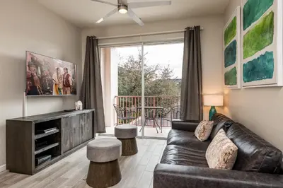 a living room with a leather couch and a balcony at Near Pool*Balcony*VistaCay Convention Ctr & Idrive in Orlando