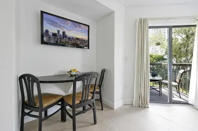 a dining room with a table and chairs and a balcony at Enclave Refurbished Condo: Just 2mi to Universal! in Orlando