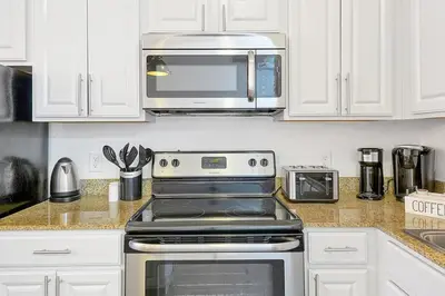 a kitchen with a stove and a microwave at International Drive Luxury Condo in Orlando