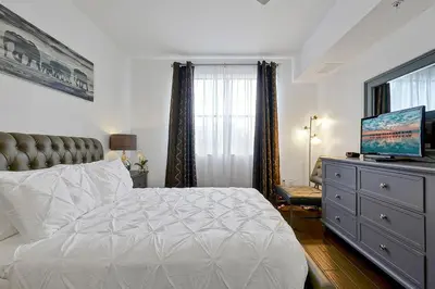 a bedroom with a bed and a dresser with a television at International Drive Luxury Condo in Orlando