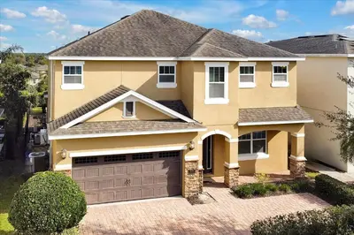 a house with a garage in front of it at Reunion Encore Resort Villa W/ Pool Spa Gameroom in Orlando