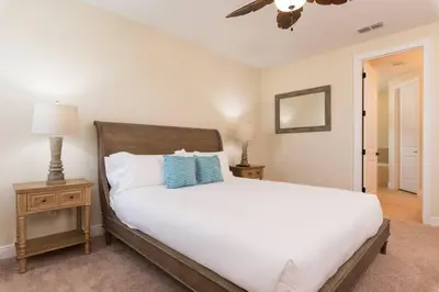 a bedroom with a white bed with blue pillows at Reunion Encore Resort Villa W/ Pool Spa Gameroom in Orlando