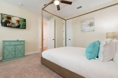 a bedroom with a white bed and a ceiling fan at Reunion Encore Resort Villa W/ Pool Spa Gameroom in Orlando