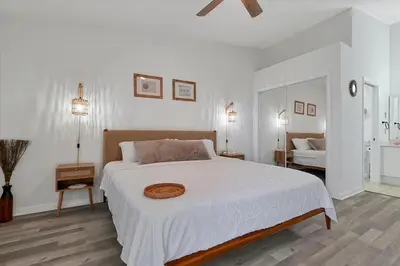 a white bedroom with a large bed with white sheets at Remodeled Retreat: Tranquil Resort Oasis Near Theme Parks in Kissimmee