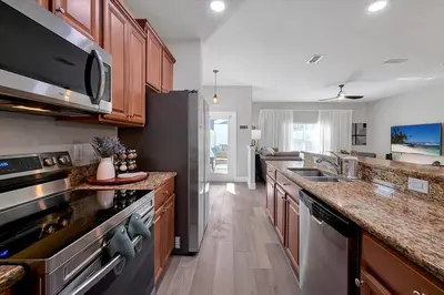 a kitchen with stainless steel appliances and wooden cabinets at Just renovated, private heated pool, resort access in Kissimmee
