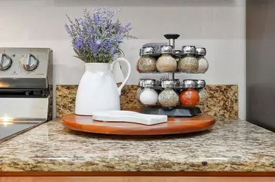 a counter with a white vase and a bunch of jars at Just renovated, private heated pool, resort access in Kissimmee