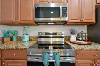 a kitchen with a stove and a microwave at Just renovated, private heated pool, resort access in Kissimmee