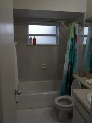 a bathroom with a tub and a toilet and a window at House of Blues-3 Bedrooms+GameRoom in Orlando