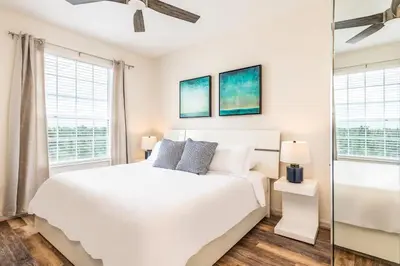 a bedroom with a white bed and two windows at Pool*Top Floor*Forest Views*Balcony*VistaCay in Orlando