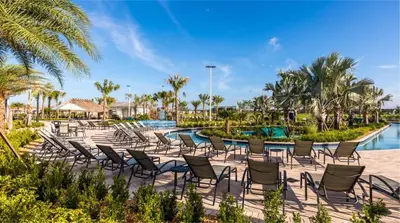 a row of chairs next to a pool at a resort at 4BR Pool Home w Free Waterpark - 9 Min to Disney in Kissimmee