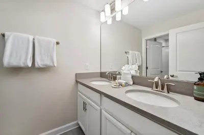 a bathroom with two sinks and a large mirror at 4BR Pool Home w Free Waterpark - 9 Min to Disney in Kissimmee